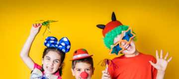 Three kids celebrating Carnival or New Years Eve at home